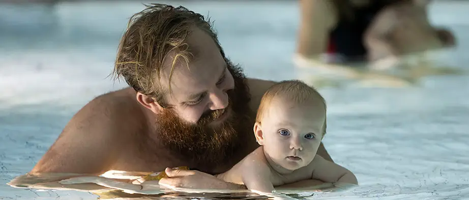En pappa och en bebis på babysim