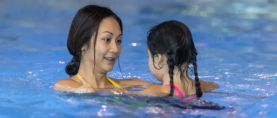 Kvinna badar med ett barn.